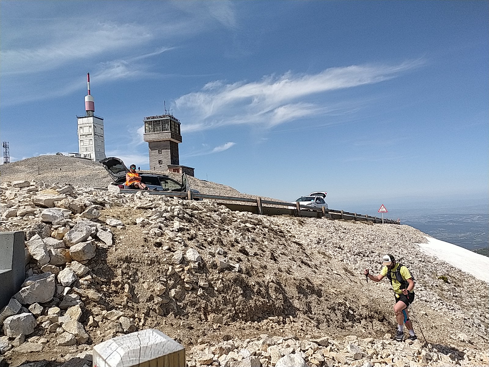 Passage d'un coureur du trail GRV by UTMB au sommet du Ventoux, on aperçoit la tour du Ventoux